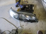 VOLVO V70 イカリング・アイライン施工 ユニットが外れたら、例のごとくヒートガンで暖めてレンズを分離します。このレンズはガラス製なので、無理をすると一瞬で割れてしまいます。力加減にはご注意ください。余熱は十分に行ってください。