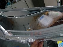 W221メルセデスのヘッドライト修理 レンズはコーキングタイプのヘッドライトのためカッティングによる殻割を行います。レンズ内側にはエアーで除去できない汚れがあったため、マイクロファイバーで優しく拭き取りを行いました。