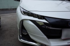 新型プリウスPHVご来店!!今回の作業内容は・・・ メーカーさんにこんな形状のバンパーを出されたら、アフターパーツメーカーのやることがなくなっちゃいますね。ヘッドライトもかなり印象的ですね。