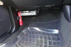 BMWコンバーチブルのナビ取付 ナビ本体はDVDの出し入れがあるので、助手席足元に配置しました。このシステムはかなりのボリュームがあり、地デジチューナーと映像セレクターが別置きとなります。配線類も専用品でカット不可能なため、機器類は助手席足元のカーペット内に全て収納しました。