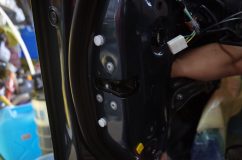 ドア内部の機械部分を取り付けている最中、技術者の手が配線を接続している様子
