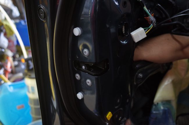 ドア内部の機械部分を取り付けている最中、技術者の手が配線を接続している様子