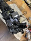 車両から取り外され、裏側が上を向いている30系アルファード後期のヘッドライトユニット。電子制御ユニットやファンらしき部品が見える。