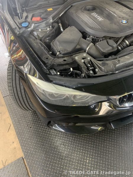 ボンネットが開けられたBMW 4シリーズ F34のエンジンルーム。ヘッドライト上部が見える。
