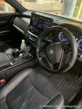 220系クラウンの運転席周りの内装。純正ナビ画面やカーボン調ステアリング、カップホルダーが確認できる。