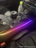 220系クラウンのセンターコンソールに、赤から紫、オレンジに変化するグラデーションのアンビエントライトが点灯した様子。