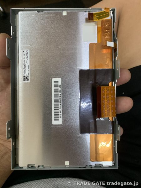 取り外したモニターの裏面、液晶パネルと接続ケーブル、製造番号が見える
