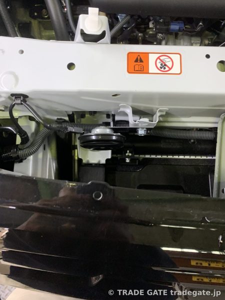 バンパー脱着されたフロント周りでホーン交換作業中の様子