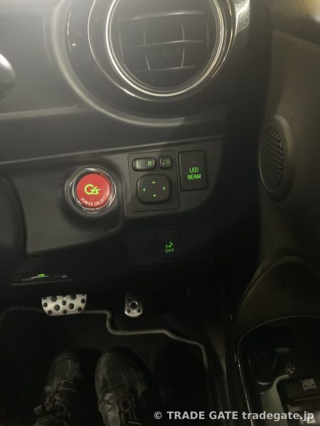 トヨタG'sアクアの運転席側ドアミラー調整スイッチ、LED BEAMスイッチ、G'sプッシュスタートボタン周辺。全体的に緑色のLEDが点灯している。