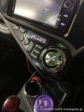 トヨタG'sアクアのセンターコンソールにあるナビ画面とエアコンパネル。エアコンパネルは緑色LEDで表示され、設定温度は22.5度と表示されている。Liptonのカップがドリンクホルダーに見える。