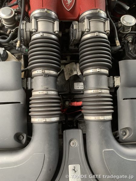 Ferrari Californiaのエンジンルーム、吸気ダクトの間から見えるバッテリーと配線。