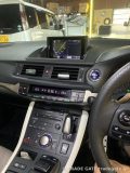 レクサスCT200hの車内、ダッシュボード中央の純正モニターにはナビ画面が表示され、エアコン操作パネルやシフトレバーが見える。