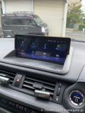レクサスCT200hのダッシュボードに設置されたAndroidモニターのホーム画面。Bluetooth、音楽、動画リストなど複数のアイコンが配置されている。