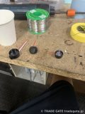 赤色LEDとメーター針の根元の部品が並べられた作業台