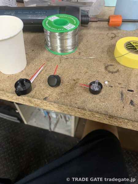 赤色LEDとメーター針の根元の部品が並べられた作業台