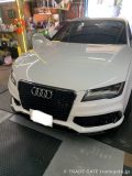 作業を終えて店舗に停車している白いAudi A7のフロント
