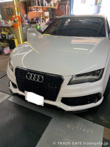 作業を終えて店舗に停車している白いAudi A7のフロント