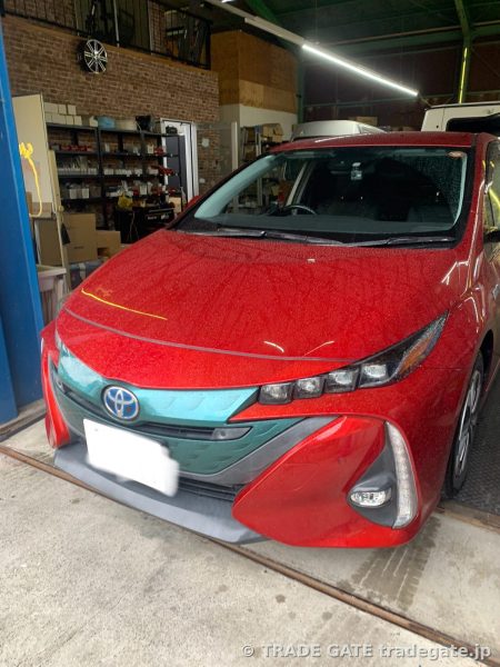 ピットに停められた赤いトヨタ50系プリウスPHEVのフロント