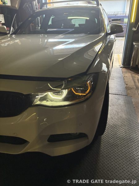白いBMW F34のフロント。右側のデイライトが特に強く黄ばんで見え、左右で色が異なっている。