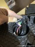 ヘッドライトユニット裏側でデイライト関連の配線作業を行っている様子。