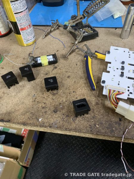 作業台に並べられたスイッチパーツと基板や工具類