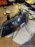 作業台に置かれた三菱ランサーのヘッドライトユニット