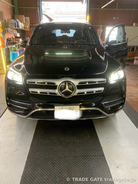 リフト上に停められた黒いMercedes GLSのフロント。ヘッドライトは点灯している。